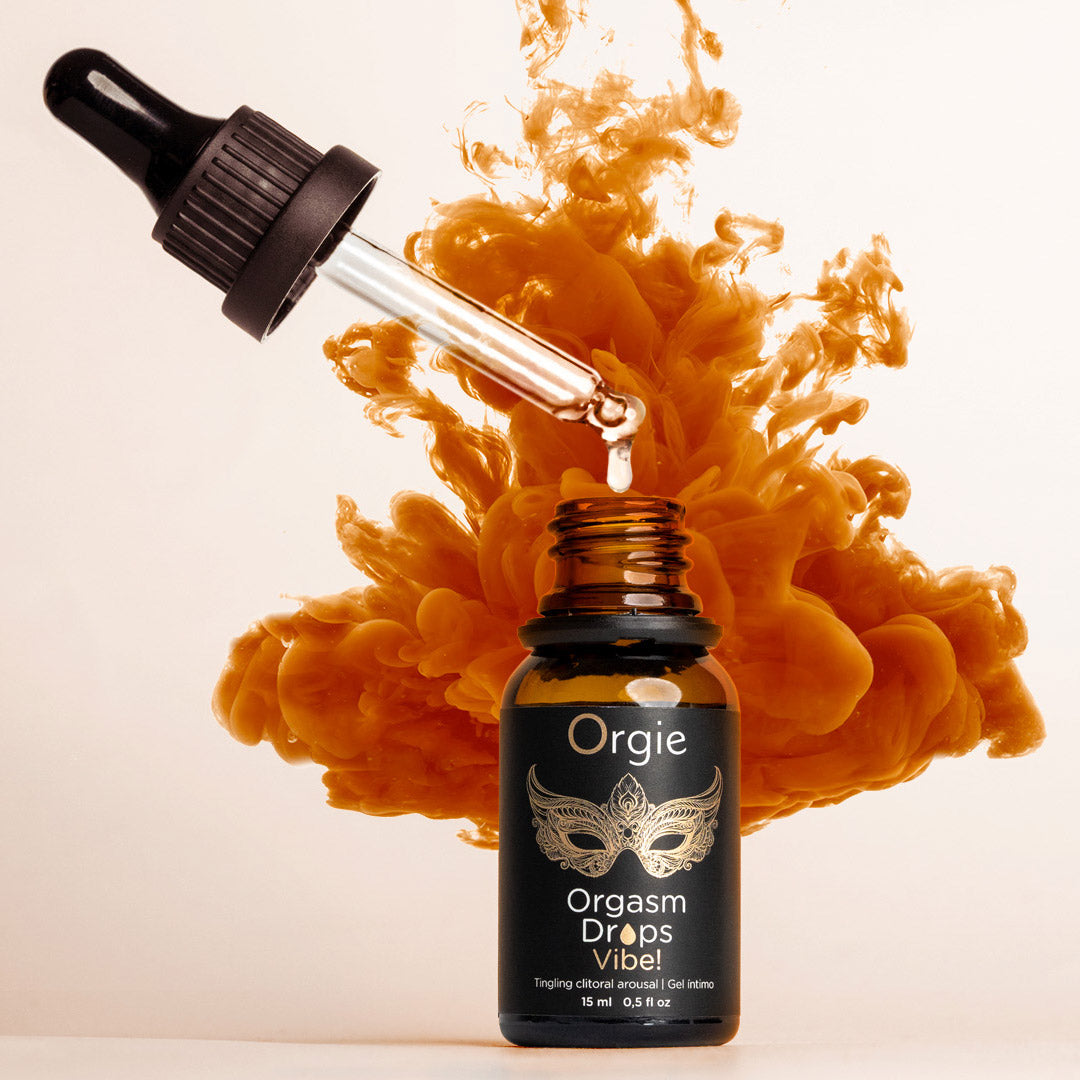 Bottle of Orgie Orgasm Drops Vital with dropper and orange smoke effect on a white background