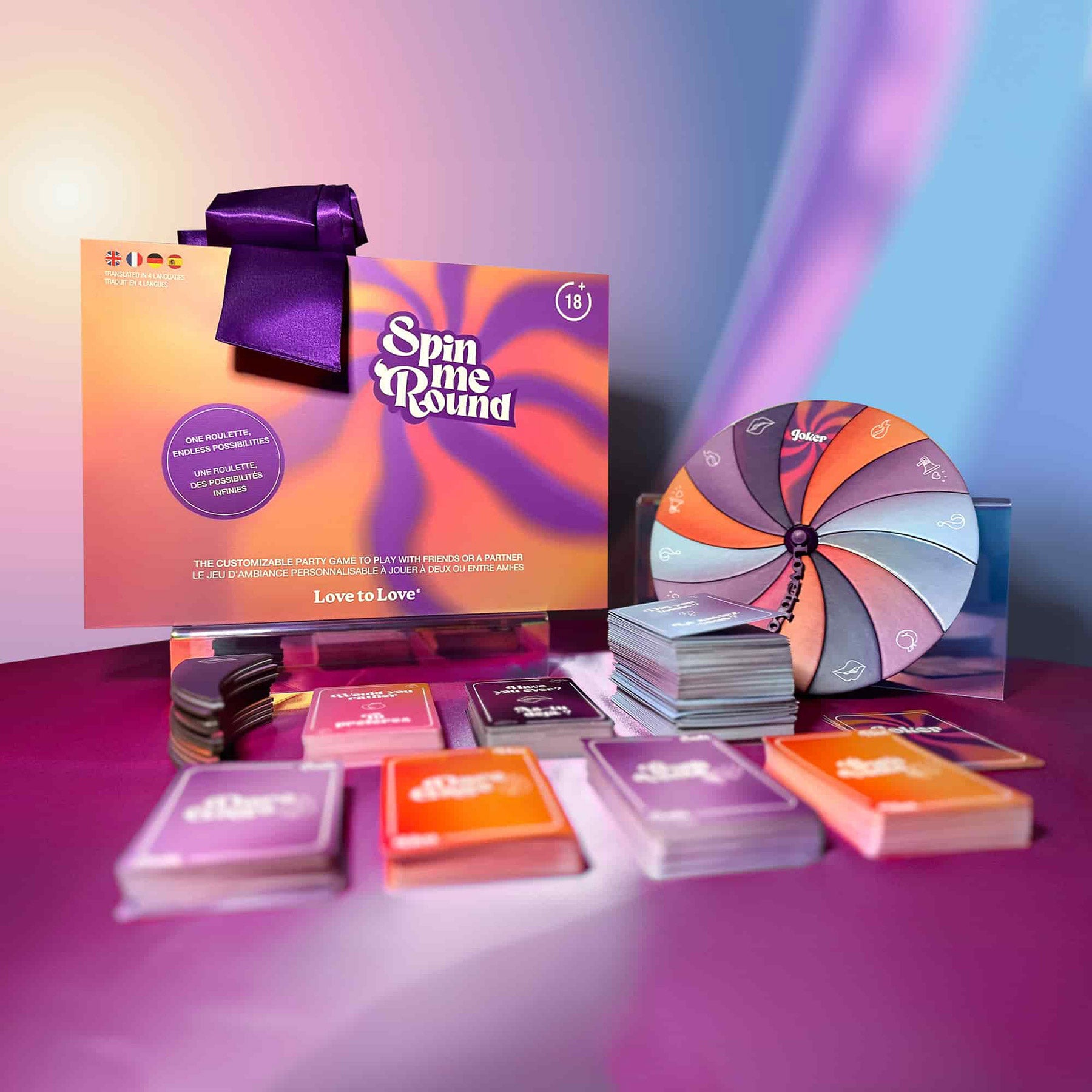 Spin Me Round game set with colorful packaging and components on a purple surface.