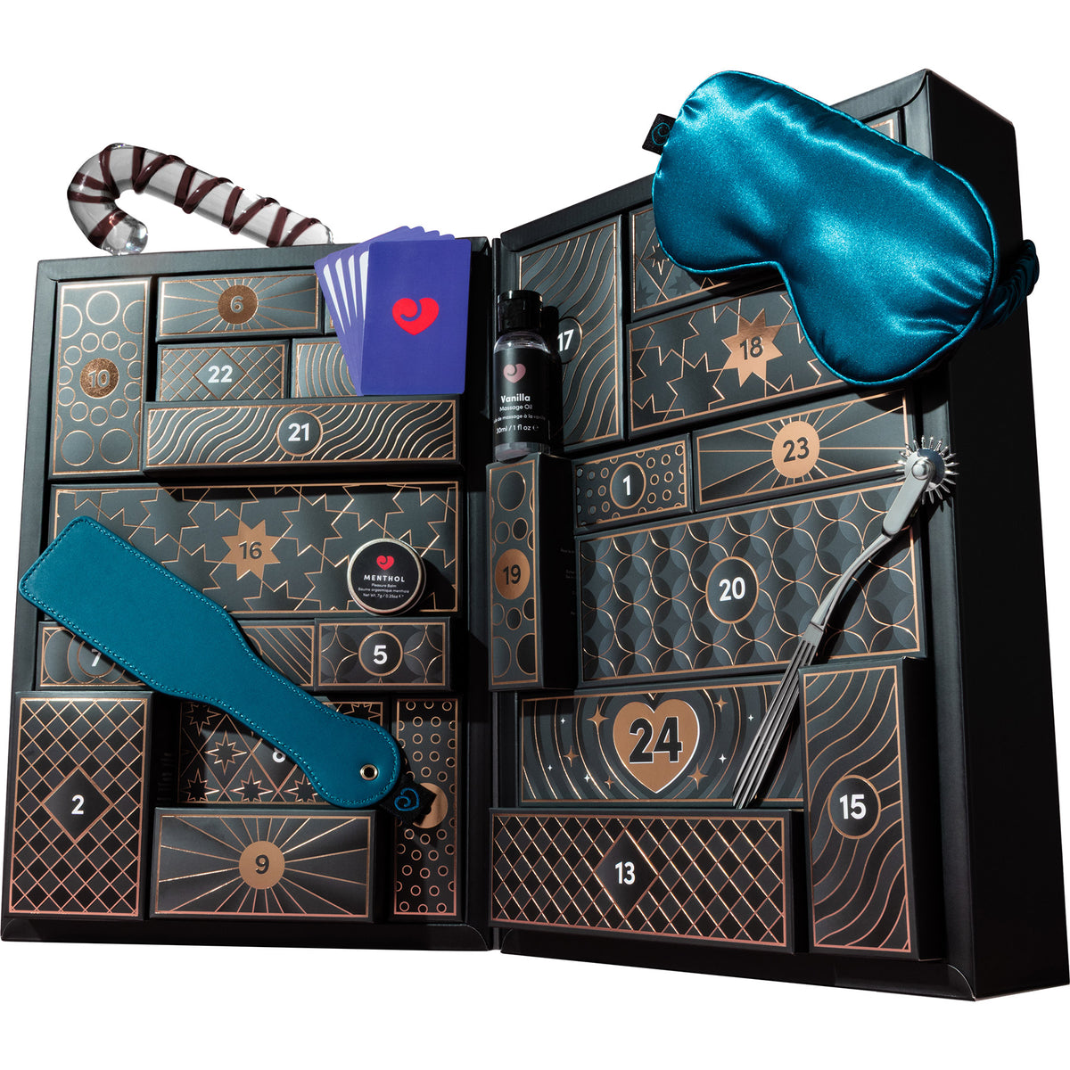 An open black advent calendar gift box with numbered compartments, gold geometric line details, and several included items: a blue satin sleep mask, a striped glass dido, a blue paddle, a tin of menthol pleasure balm, a small purple card with a red heart, and a black-and-silver curved accessory.