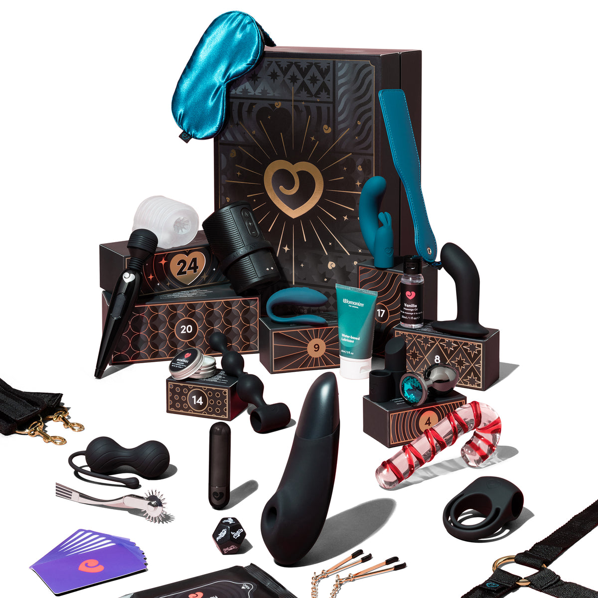 A curated adult gift set arranged in front of a branded presentation box on a clean white studio background. The set includes multiple black intimate massagers and accessories, teal-blue accessories, a turquoise sleep mask, a small tube, a pouch with chains, cards, and a red-and-white striped candy cane dildo.