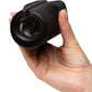 A hand holding a black textured cylindrical personal massager with a flared opening, shown against a plain white background.