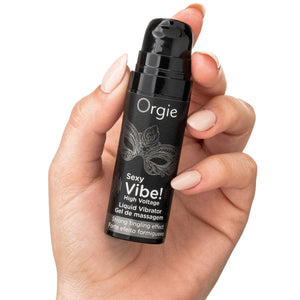 Hand holding a black bottle labeled 'Orgie Sexy Vibe!' against a white background