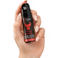 Hand holding a bottle of Orgie Touro XXXL product on a white background