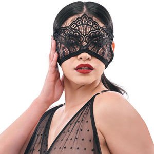 Woman wearing a black lace eye mask on a white background