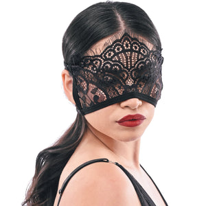 Woman wearing a black lace eye mask on a white background