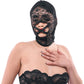 Person wearing a black lace hood and bodysuit on a white background