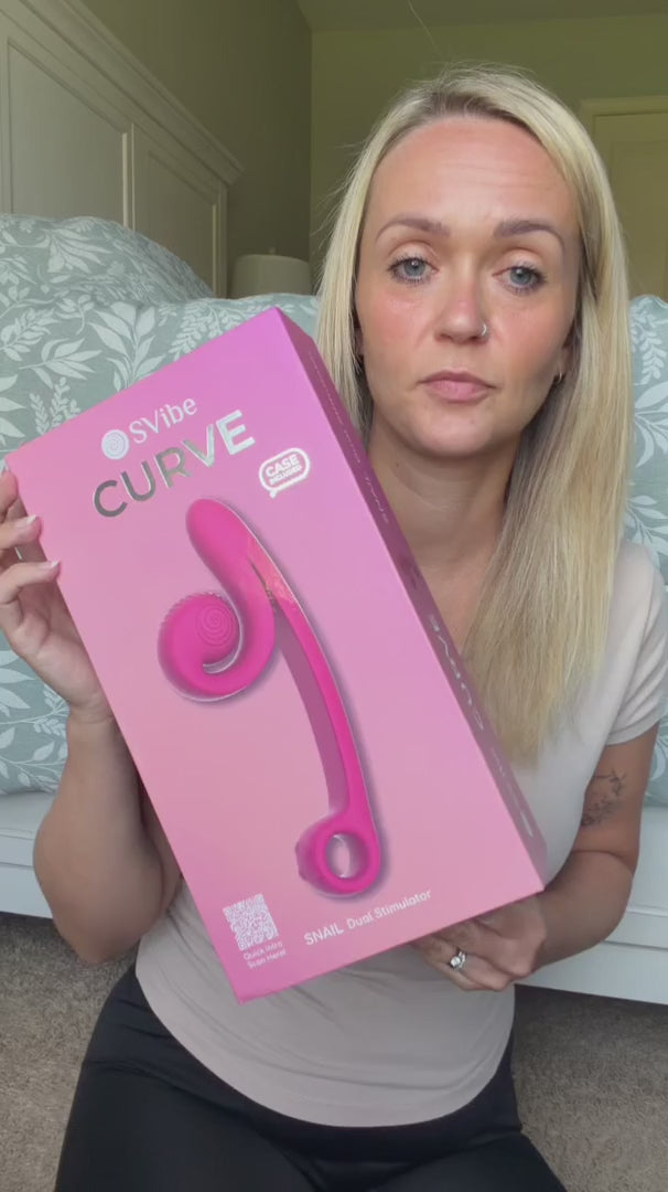 Load video: Discover the SVibe Snail Curve, featuring an ergonomic shape, a textured clitoral head, and a comfortable handle. Experience the innovative Slide'n'Roll Technology that synchronizes clitoral and vaginal orgasms for unparalleled pleasure.  With two powerful motors and separate controls, this body-safe, ultra-soft silicone vibrator guarantees 100% satisfaction. Equipped with magnetic wireless charging and a waterproof design, it's the perfect companion for solo or partnered play.